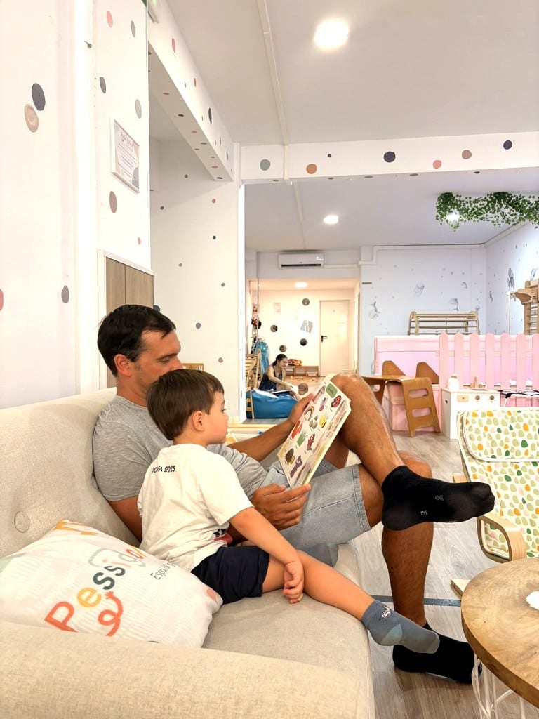 Padre con su hijo leyendo en el sofá de Pessigolles